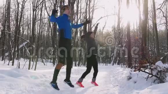 年轻人和女人在冬天的早晨公园做运动慢跑前热身视频的预览图