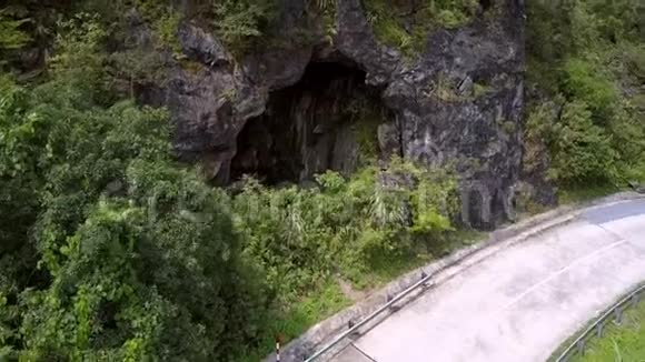 在丛林之间用公路曲线放大岩石洞穴视频的预览图