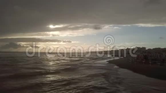 海岸线上令人印象深刻的日落阴云密布的天空强烈的光和海暴视频的预览图