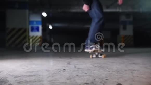地下停车场一个年轻人在玩滑板在练习翻转视频的预览图