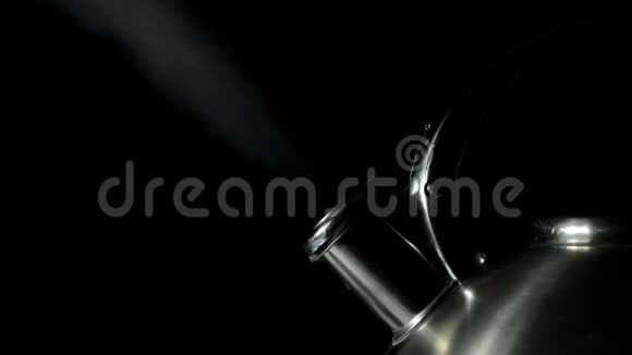 用汽笛在黑色背景上用蒸汽喷出的钢制水壶视频的预览图