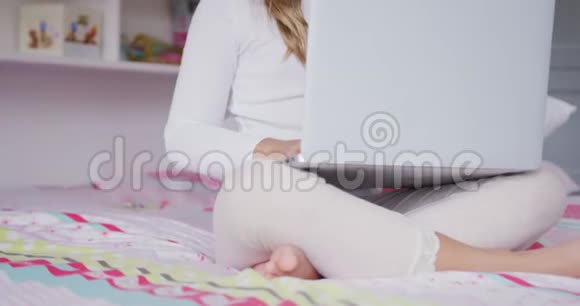 卧室里有笔记本电脑的女孩舒适的家4k视频的预览图