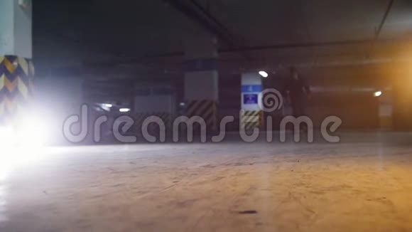 地下停车场一个年轻人在玩滑板练习他的滑冰技巧视频的预览图
