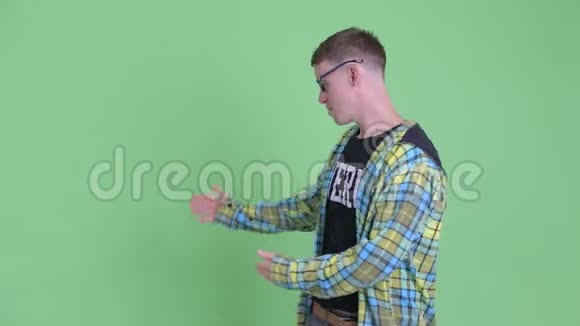 快乐的书呆子男人向后展示并竖起大拇指的肖像视频的预览图