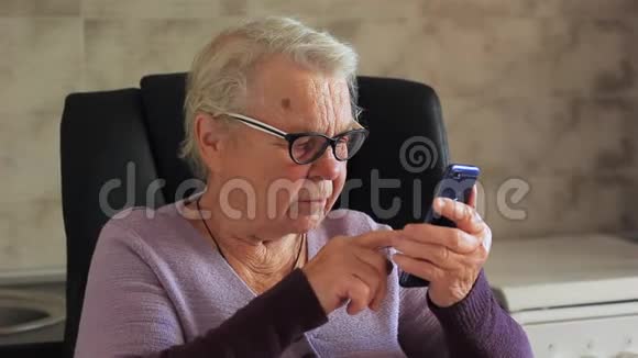 老年妇女带移动设备的祖母视频的预览图