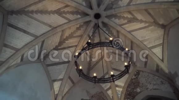 从底部看旧吊灯以轮子的形式在教堂或教堂的天花板上悬挂灯泡视频的预览图