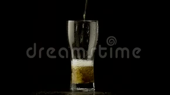 啤酒倒在黑暗的背景上的玻璃杯里视频的预览图