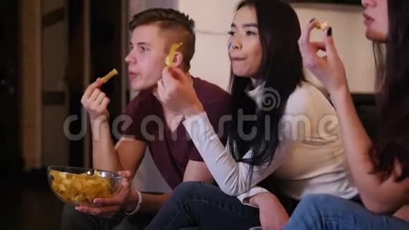 四个年轻人看足球比赛吃垃圾食品谈论比赛视频的预览图