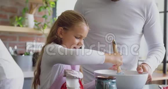 父亲和女儿在家里的厨房里做饼干视频的预览图