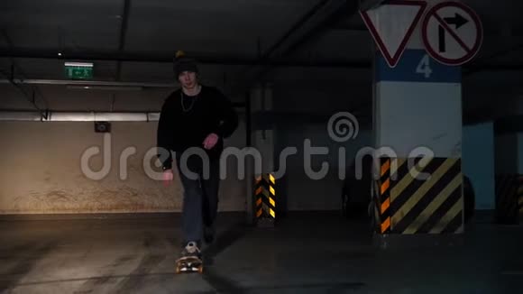 地下停车场一个练习滑板技能的年轻人滑向摄像机视频的预览图