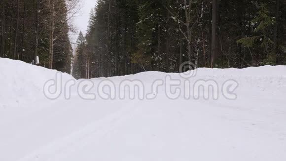 两辆工业卡车沿着一条冬季森林道路行驶视频的预览图