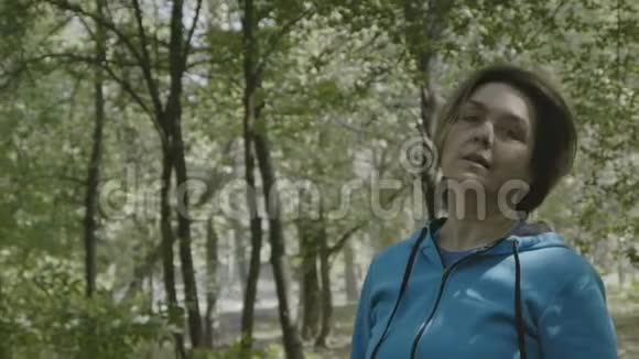 中年妇女在森林中摇头慢动作视频的预览图