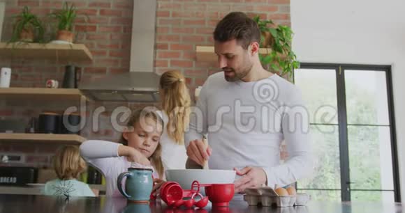 父亲和女儿在家里的厨房里做饼干视频的预览图