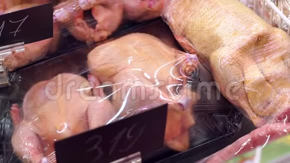 在一家大型超市的柜台上出售新鲜的母鸡和鸭子视频的预览图