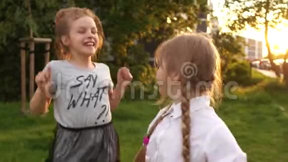 两个十几岁的女孩欢乐地跳着暑假快乐的童年回到学校户外画像视频的预览图