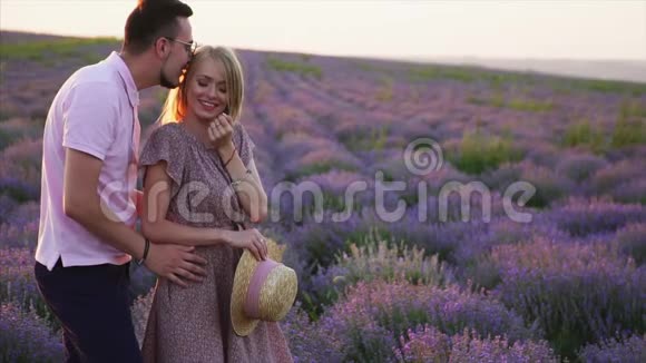 年轻浪漫的情侣拥抱在盛开的薰衣草田野里视频的预览图