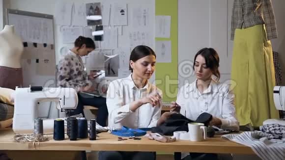 两个漂亮的年轻女人在缝纫工作室工作视频的预览图