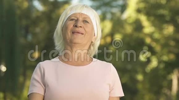 活跃的退休女士举起哑铃在公园做手臂运动精力充沛视频的预览图