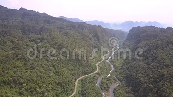 绿色的雨林在柏油路上方的高山上升起视频的预览图