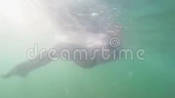 太阳下海水中漂浮的女人的剪影视频的预览图