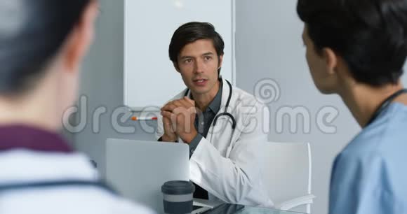 年轻医生坐在桌子旁咨询视频的预览图