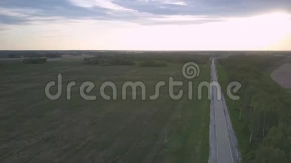 在暮色苍茫的田野间天桥在宽阔的公路上移动视频的预览图