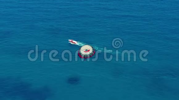 空中观景坐着降落伞在船后面飞行海上极限水上运动寄生虫视频的预览图
