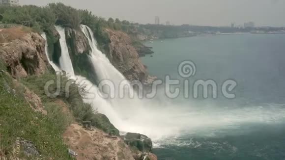 五颜六色的瀑布水流下来充满绿色的石崖视频的预览图