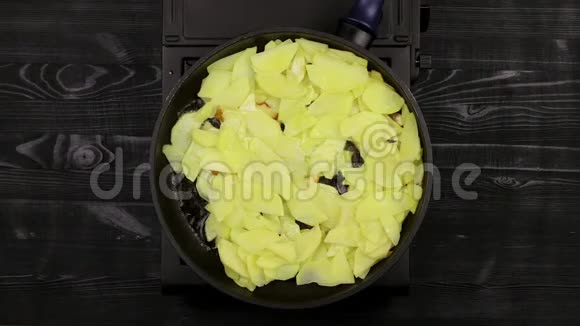 女的厨师她的双手翻过切片的土豆片煎锅里煎直到金黄油在底部沸腾顶级v视频的预览图
