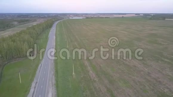 Flycam沿着公路在田野和森林地带之间移动视频的预览图