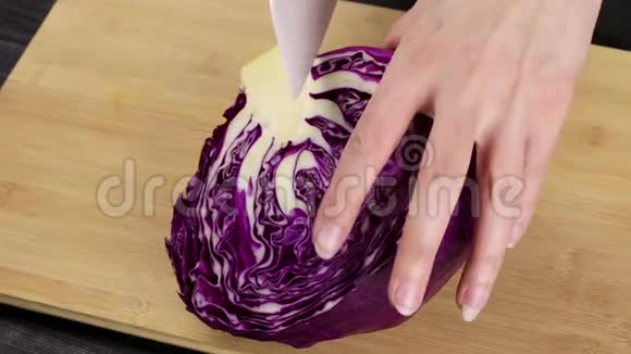 厨师的女手把红卷心菜切成沙拉或炖菜在自制的r上烹饪过程的一部分视频的预览图