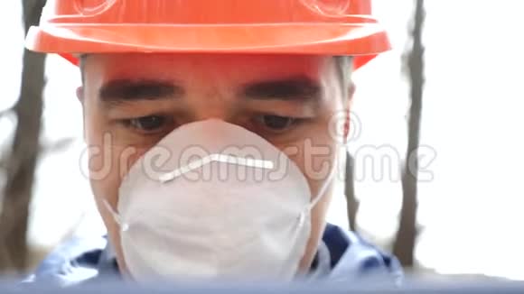 环境污染戴头盔戴口罩戴口罩的人可以测量废水的污染程度视频的预览图