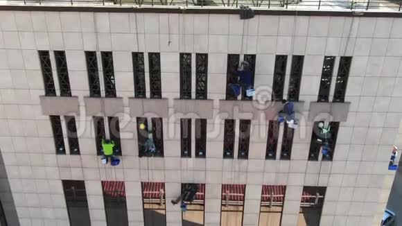 办公楼一侧有人擦窗户的空中镜头视频的预览图