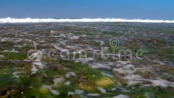 巨大的泡沫海浪在海岸线上缓慢地翻滚视频的预览图