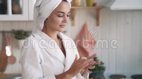 贴身穿浴袍的女孩头上有毛巾脸上涂着奶油动作缓慢视频的预览图