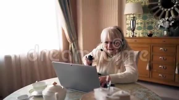 金发奶奶在家玩电脑游戏非常兴奋视频的预览图