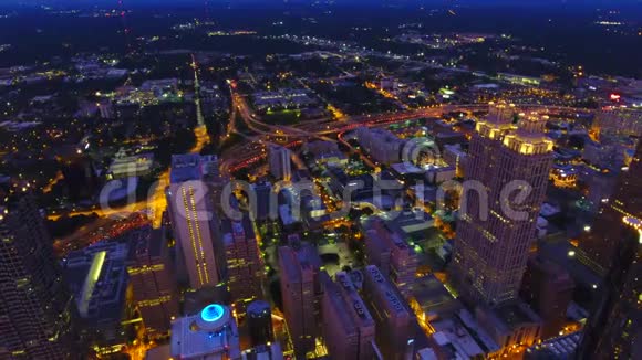 亚特兰大市中心的灯在黄昏摄像机在市中心上空盘旋实时静态视图高速公路前照灯视频的预览图