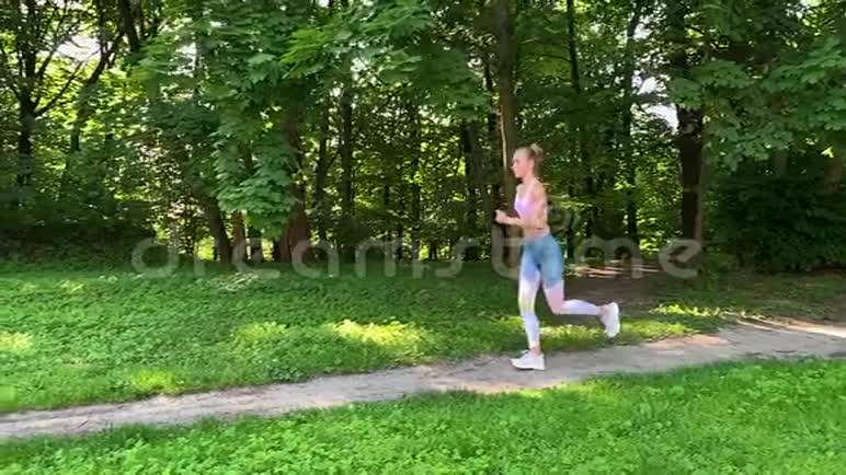 健康的生活方式女人在森林小径上慢跑慢动作视频的预览图