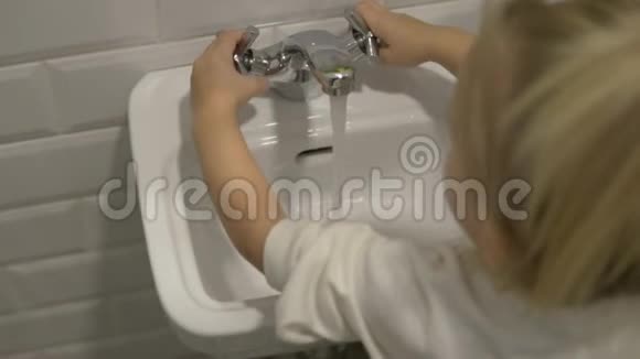 小女孩打开孩子们手脸盆里的水视频的预览图