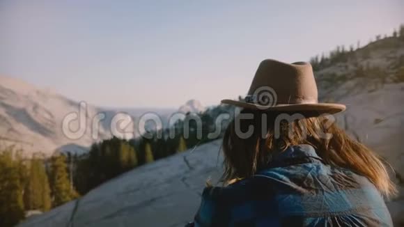 在约塞米蒂国家公园年轻的旅游女孩独自坐在岩石上观看美丽的山景视频的预览图