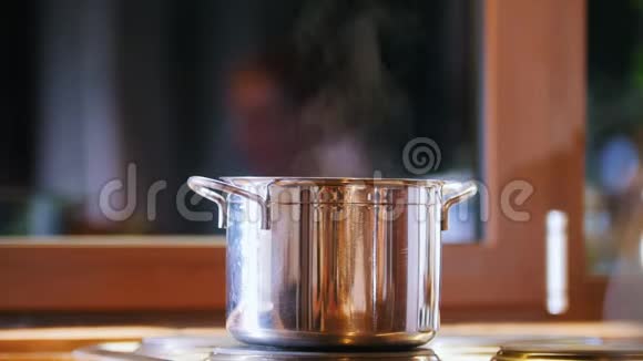 锅在滚刀上蒸汽来了在窗户的背景上视频的预览图