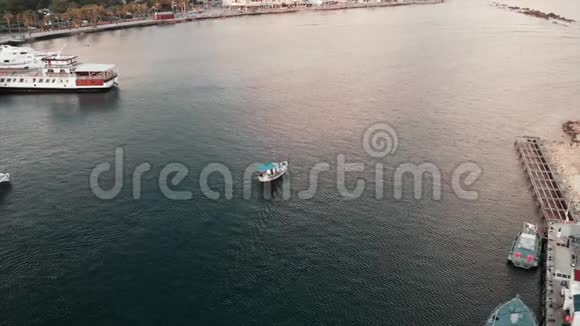 在城市港口航行的蓝色屋顶的白色小渔船的鸟瞰图视频的预览图