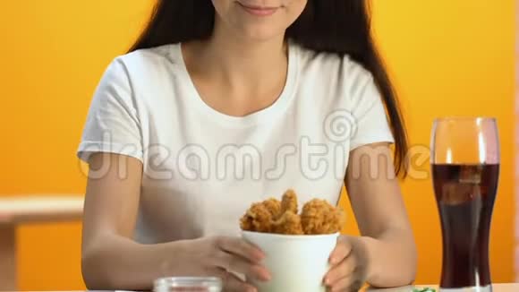 令人愉快的女人闻着香脆的炸鸡微笑着进入相机视频的预览图