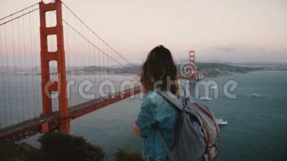 年轻的快乐旅游妇女带着背包散步观看加州标志性金门大桥景观的壮丽景色视频的预览图