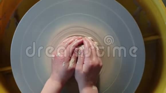 陶工在制陶车间的轮子手工陶器里面孩子们的手在陶轮上工作塑造粘土视频的预览图