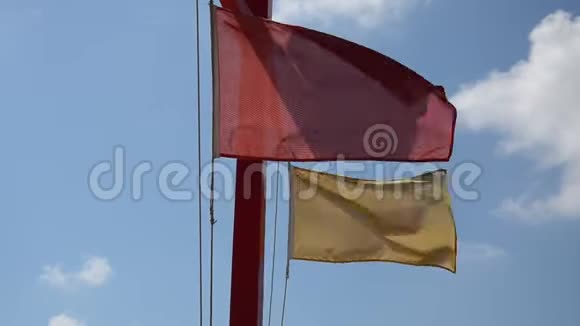沙滩上的红黄旗随风飘扬视频的预览图