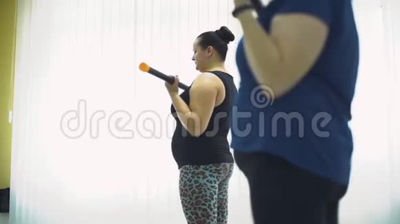 肥胖妇女在健身房和杠铃一起工作视频的预览图
