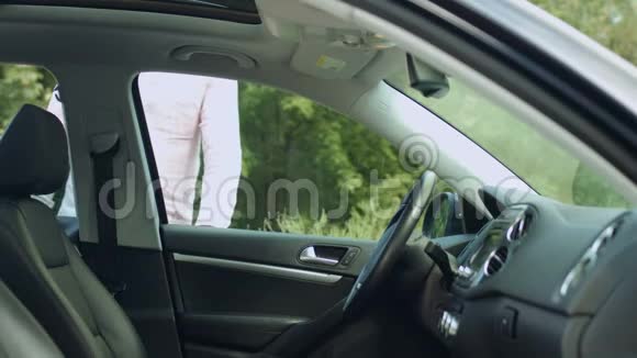 英俊的男司机在车上系安全带视频的预览图