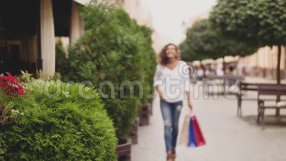 快乐时尚的女人带着购物袋走在街上视频的预览图