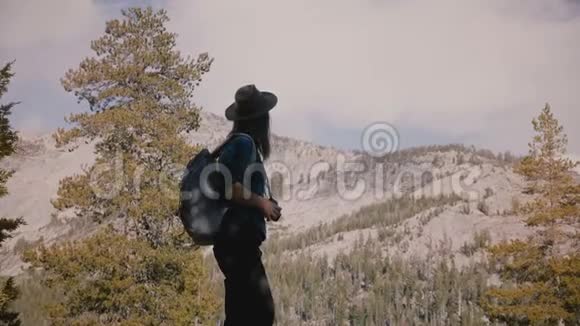 年轻美丽的旅游女孩带着背包在约塞米蒂国家公园慢动作拍摄惊人的白色岩石照片视频的预览图